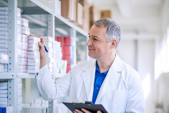 a pharmacist looks at a stock of medicines and makes an inventory