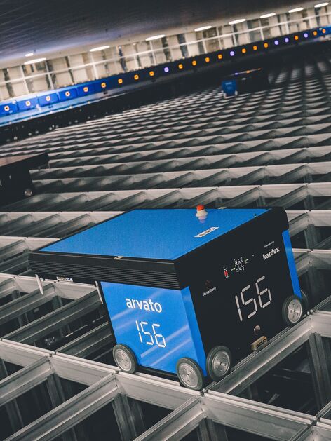 AutoStore system with AutoStore robot from Kardex operating on a grid for automated warehouse fulfillment