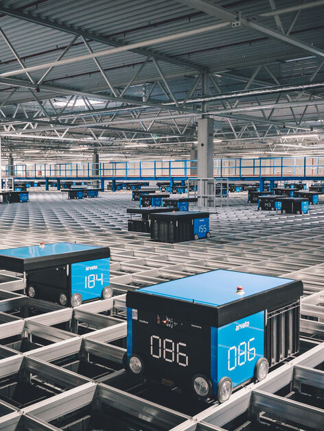 A logistics AutoStore grid with moving robots in an arvato warehouse