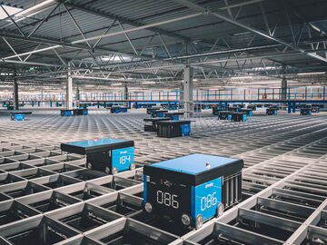 A logistics AutoStore grid with moving robots in an arvato warehouse