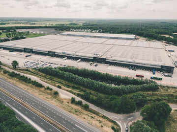 an aerial view of a complete logistics site with solar panels for sustainability on the roof