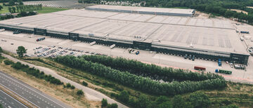 an aerial view of a complete logistics site with solar panels for sustainability on the roof
