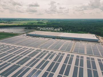 Aus der Vogelperspektive: Arvato-Gebäude mit Photovoltaikanlagen auf dem Dach