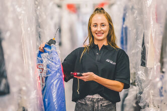 An employee scans a blue jacket for a client order