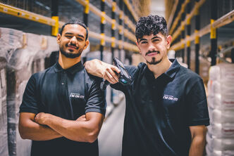 Two warehouse employees working together as a team