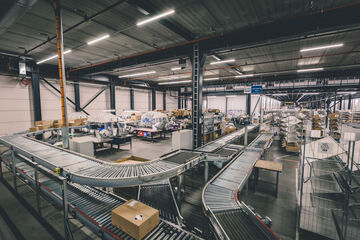 Conveyor belt system moving parcels through an automated warehouse fulfillment process