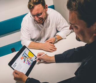 an employee shares information on his Ipad with a colleague