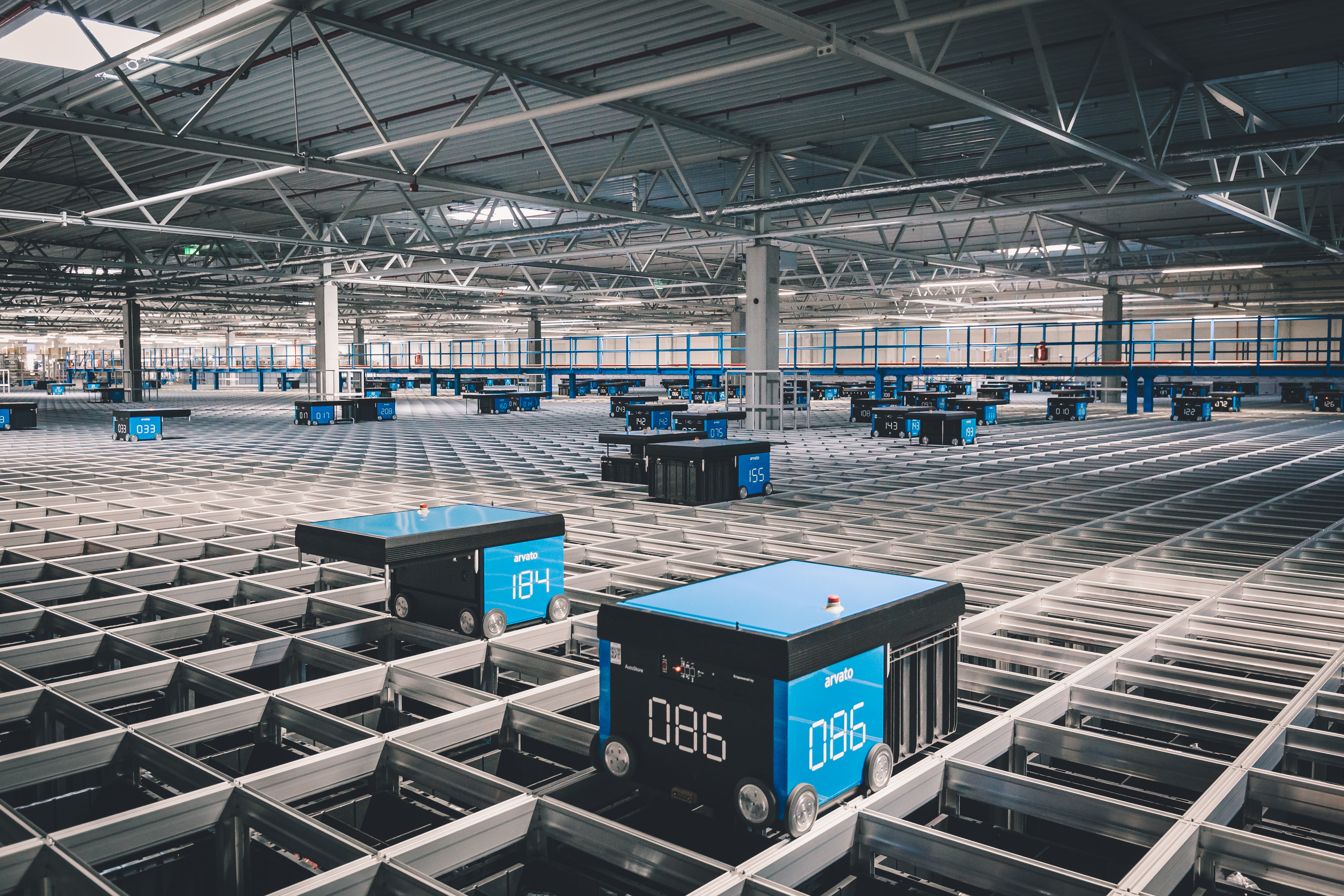 A logistics AutoStore grid with moving robots in an arvato warehouse